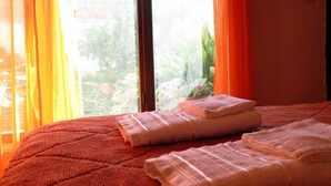 A bed with a red quilt and two neatly folded white towels. - Posada Galicia (Villa Maria)