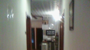 A narrow hallway with a tiled floor leading to a kitchen area. - Hostal Central (Zaragoza)