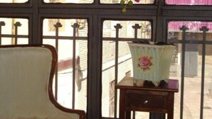 A room with a chair and a table near a window with a view of buildings. - Hostal Central (Zaragoza)