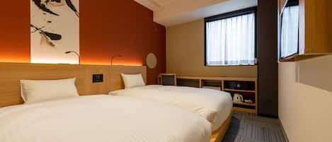 Habitación de hotel con dos camas, televisión, escritorio y ventana con cortinas.
