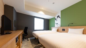 Une chambre d’hôtel avec deux lits, un bureau avec un ordinateur, une chaise et une grande fenêtre.