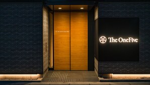 A hotel entrance with a modern design, featuring a large illuminated sign reading "The OneFive" and a wooden door with a patterned design. - The OneFive Kyoto Shijo (Kyoto)