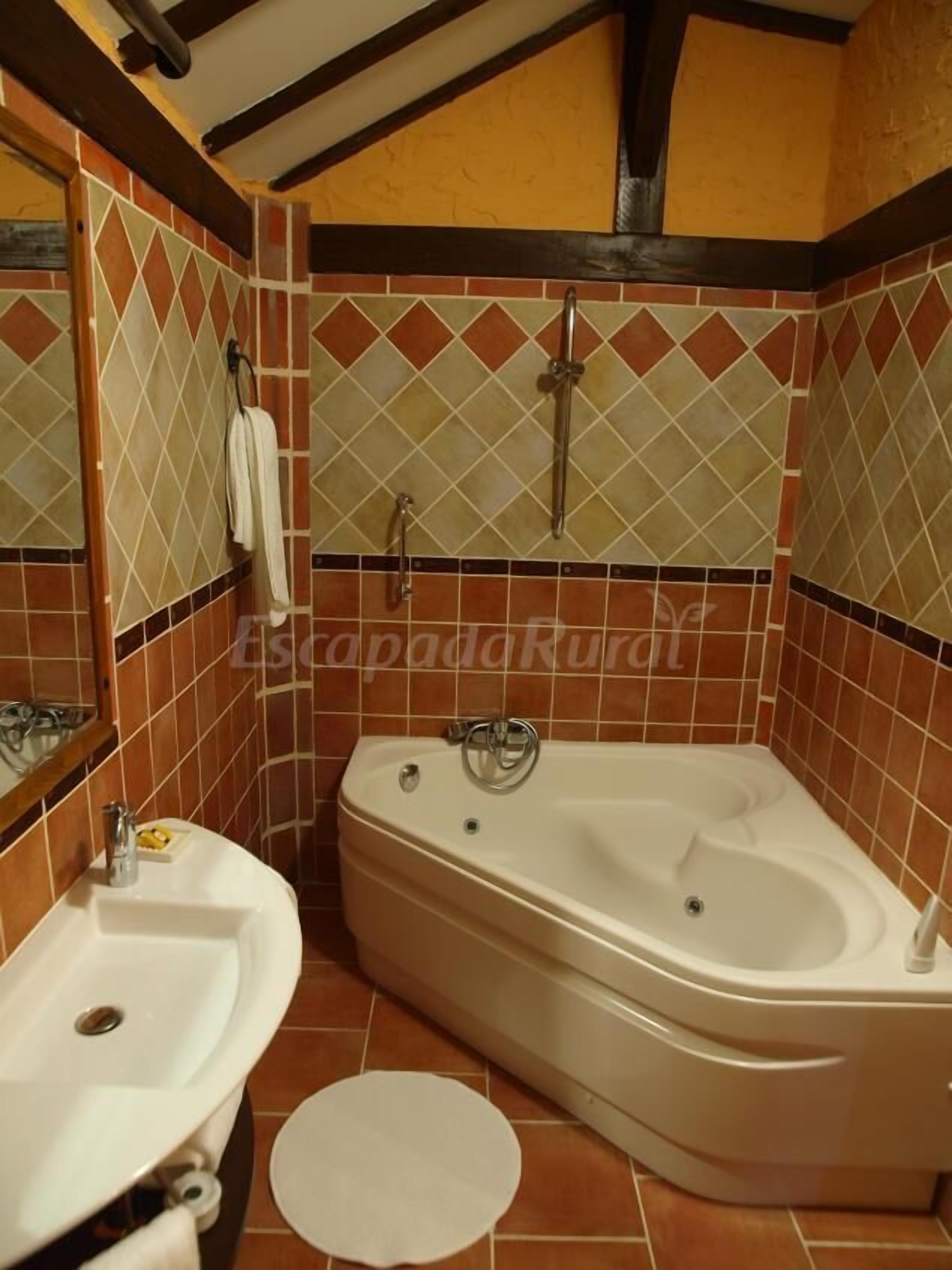 Une salle de bain avec une baignoire, deux lavabos et un miroir.