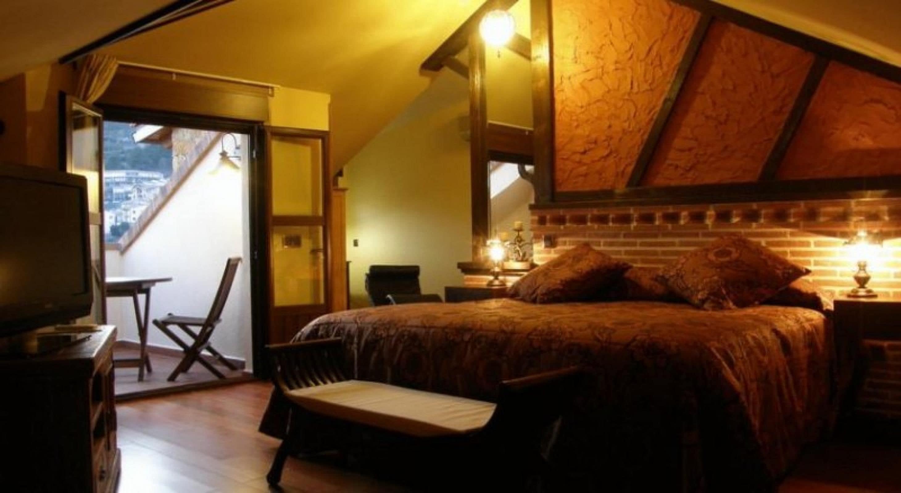 Un dormitorio con cama, escritorio, silla y televisor.