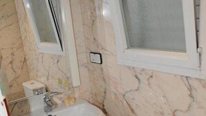 A bathroom with a white sink, a toilet, and a mirror.