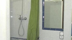 A bathroom with a shower, a sink, and a mirror.