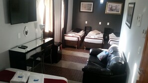 A hotel room with a bed, a desk, a chair, a couch, and a TV. - Hotel Buriti Itupeva (Itupeva)