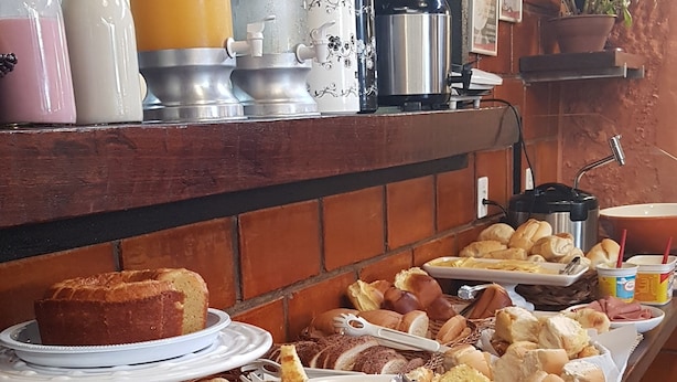 A buffet with various food items including bread, pastries, and fruit. - Hotel Buriti Itupeva (Itupeva)