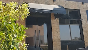 A building with a reception area, large windows, and a car parked in front. - Hotel Buriti Itupeva (Itupeva)