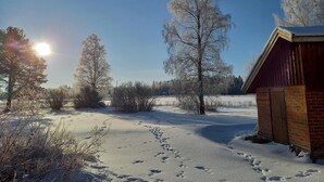A snow-covered landscape with a wooden cabin and a clear sky. - Opintola Bed & Breakfast (Teuva)