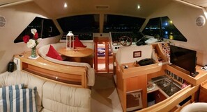 A yacht interior with a dining area, a control station, and a seating area with cushions. - Yacht Suite Forio Ischia (Forio)