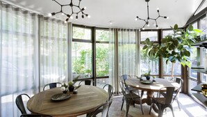 A dining area with a round wooden table, metal chairs, and a potted plant. - WOW Apartments & Rooms (Gothenburg)