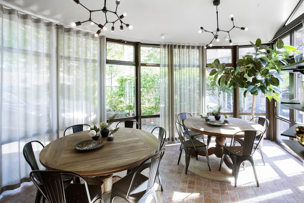A dining area with a round wooden table, metal chairs, and a potted plant. - WOW Apartments & Rooms (Gothenburg)