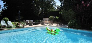 Una piscina al aire libre, tumbonas