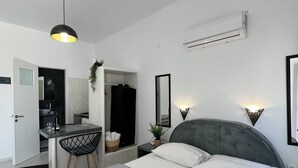 A modern bedroom with a large bed, bedside tables, a desk, and a chair. - Santo Margarita (Santorini)