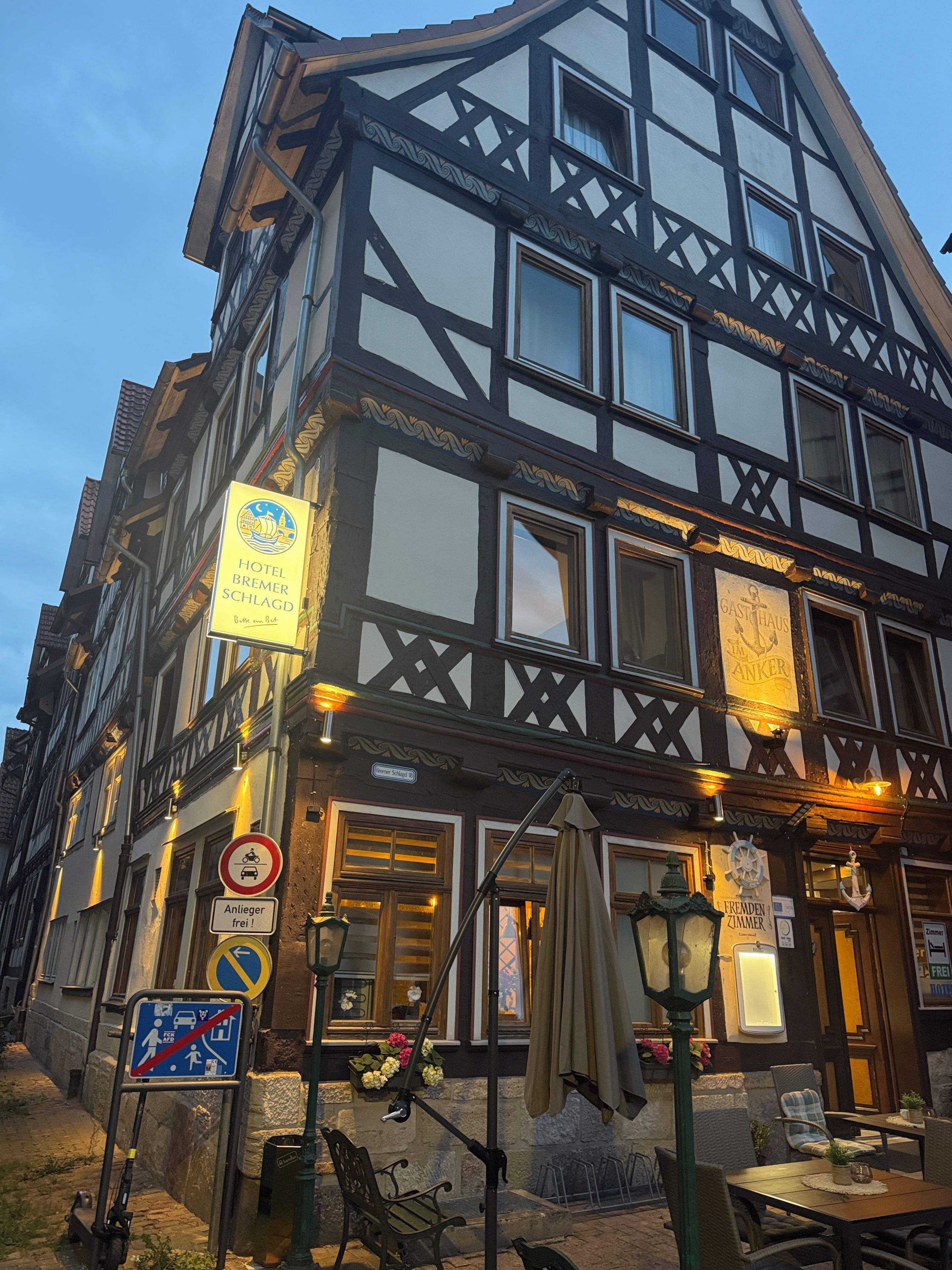 Un edificio tradicional con entramado de madera con letreros que indican Hotel Bremer Schloss y un restaurante llamado GASTHAUS ANKER.
