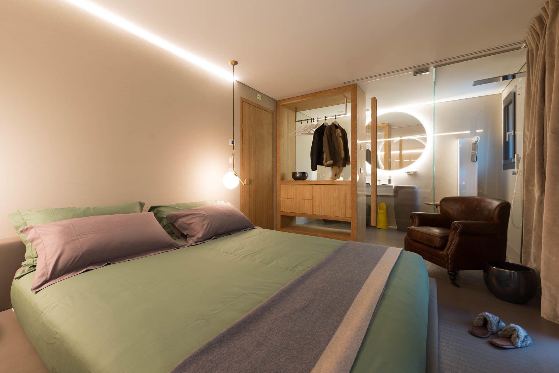 Una camera da letto moderna con un letto, un armadio in legno, uno specchio, una sedia e un tavolino.