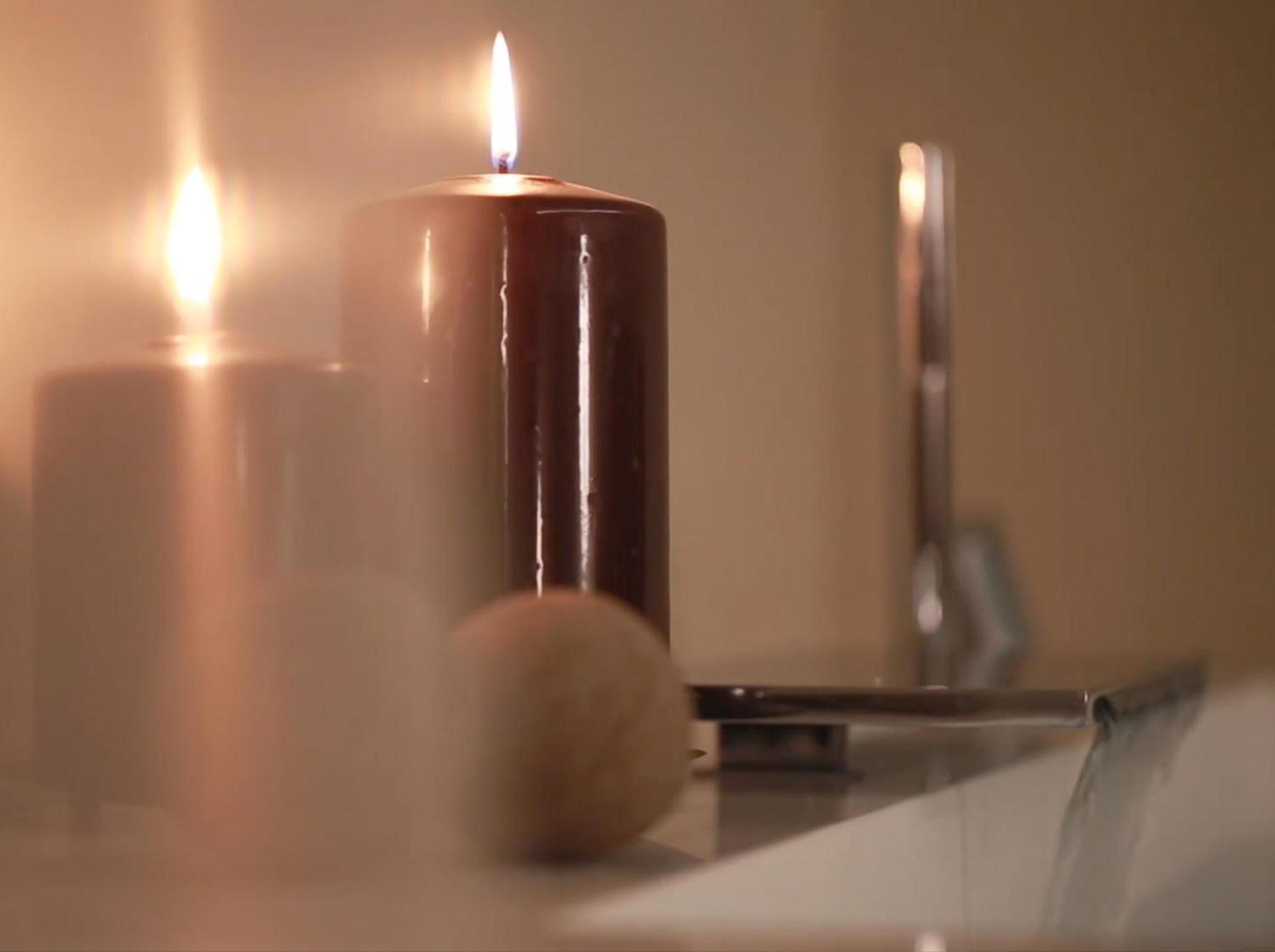 Une bougie posée sur une table dont la surface est réfléchissante.
