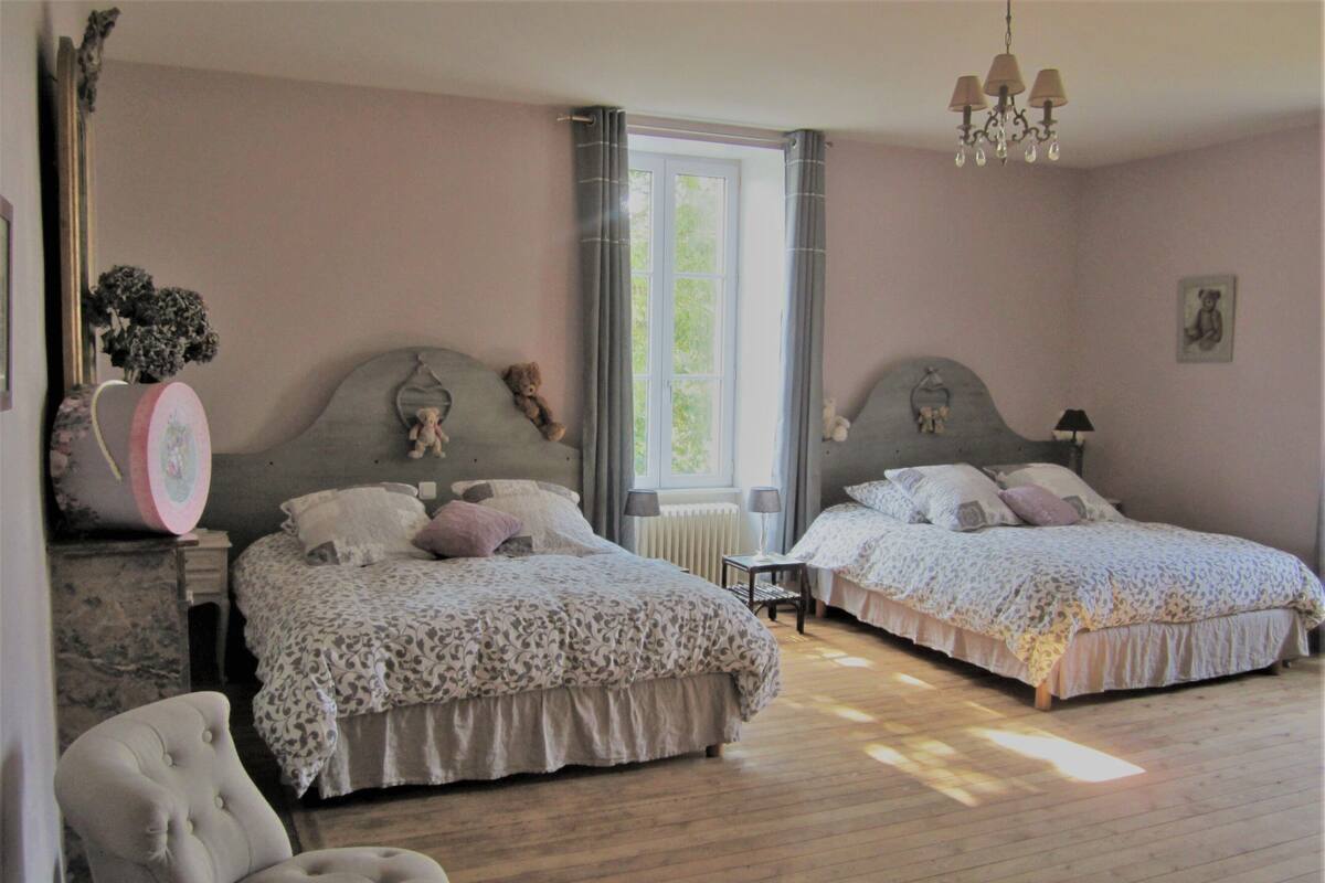 A bedroom with two beds, a chair, a dresser, and a window with curtains.