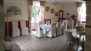 Une salle à manger avec un sol à motifs, un lustre et un tableau accroché au mur.