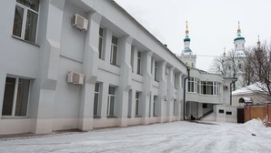 A large building with multiple windows and a covered walkway.