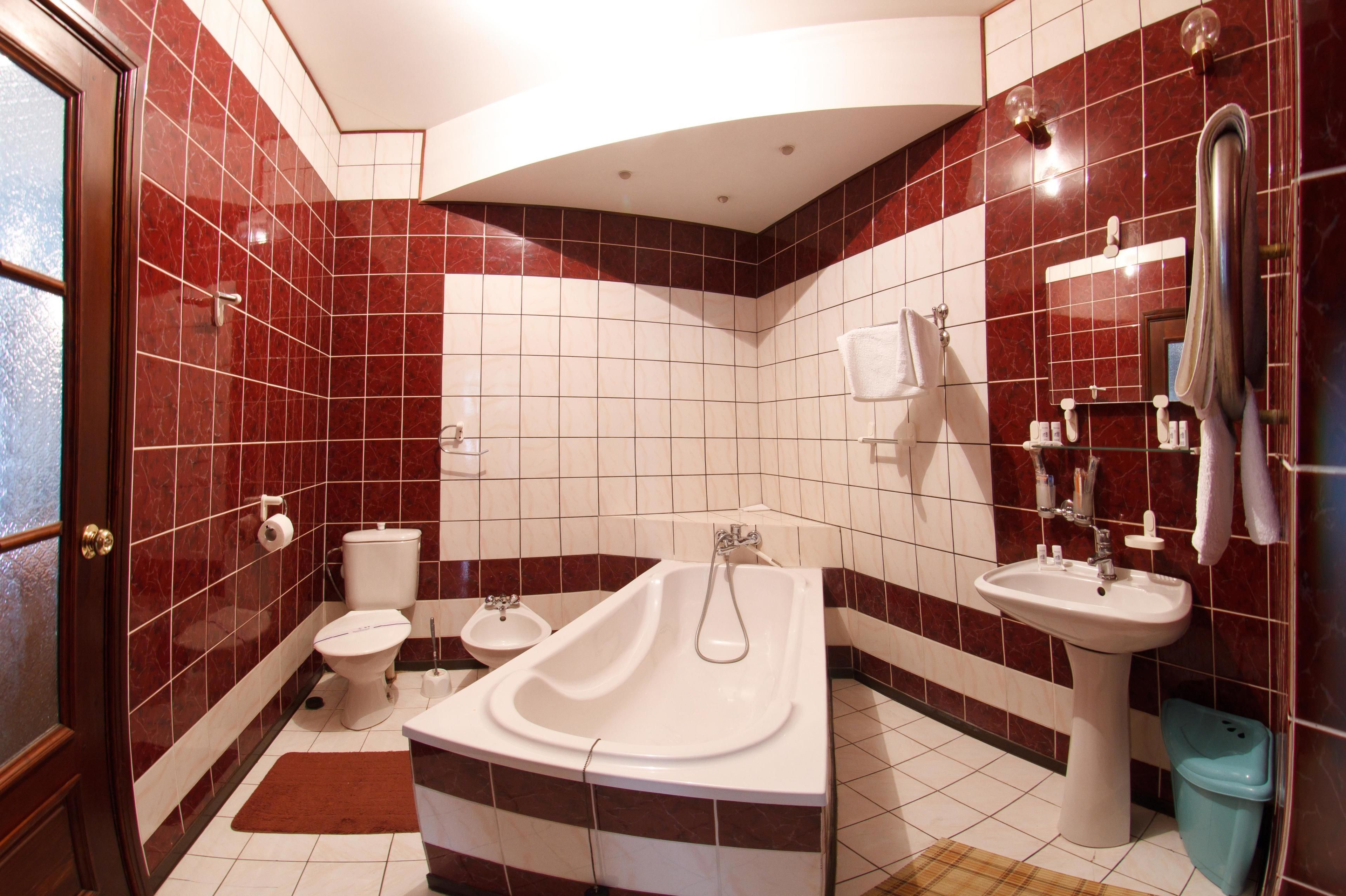 A bathroom with a bathtub, toilet, sink, and a shower area.