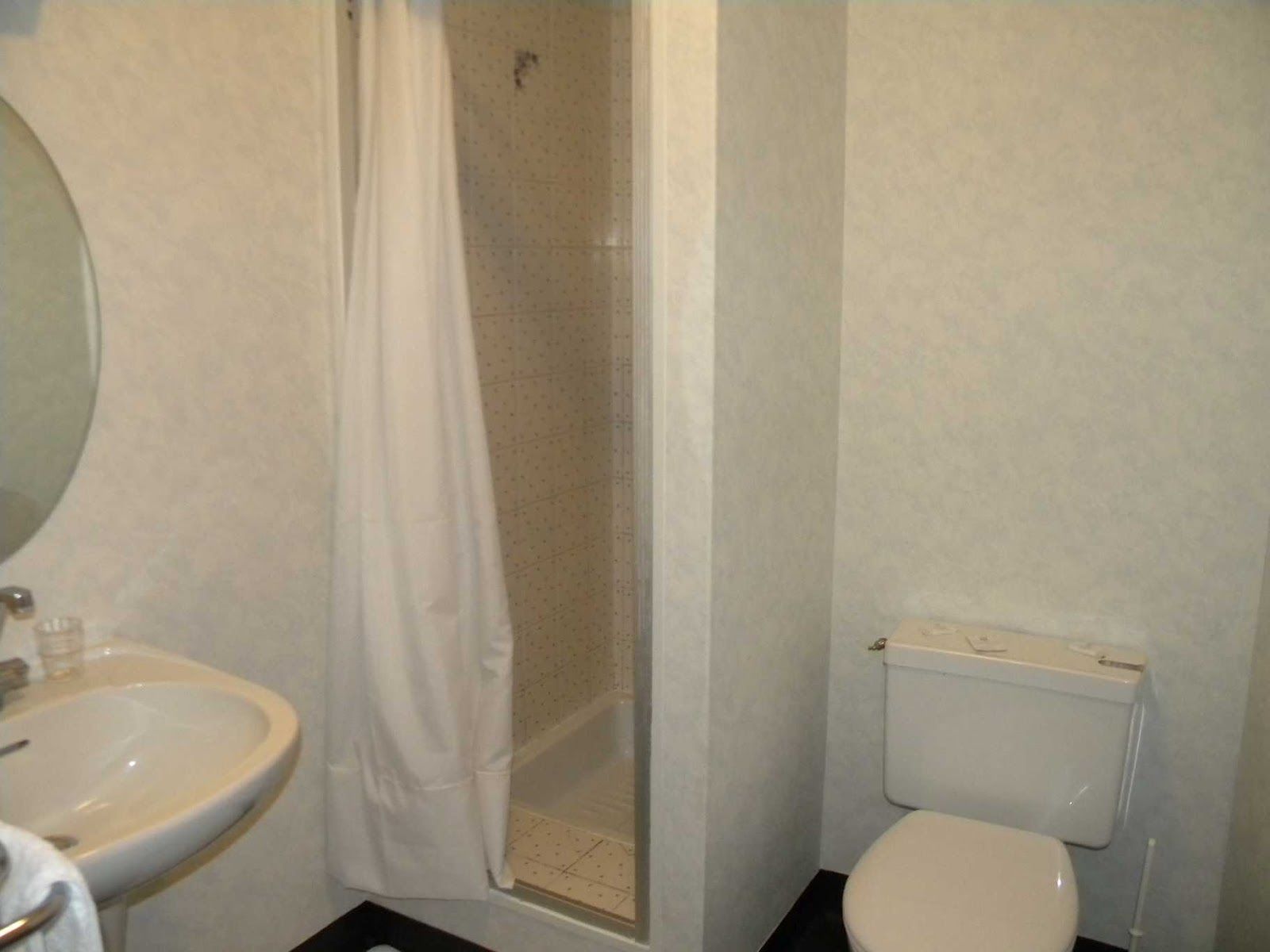 A bathroom with a sink, toilet, and shower.
