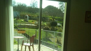 A room with a sliding glass door leading to an outdoor patio area. - Auberge de Pen Mur (Muzillac)