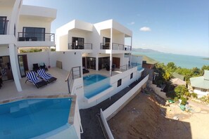 A modern multi-story building with a rooftop pool and a view of the sea. - 2 Bed Seaview Villa A2 SDV202-By Samui Dream Villas (Koh Samui)