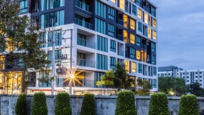 Un hotel de varios pisos con diseño moderno, con balcones y ventanas amplias.