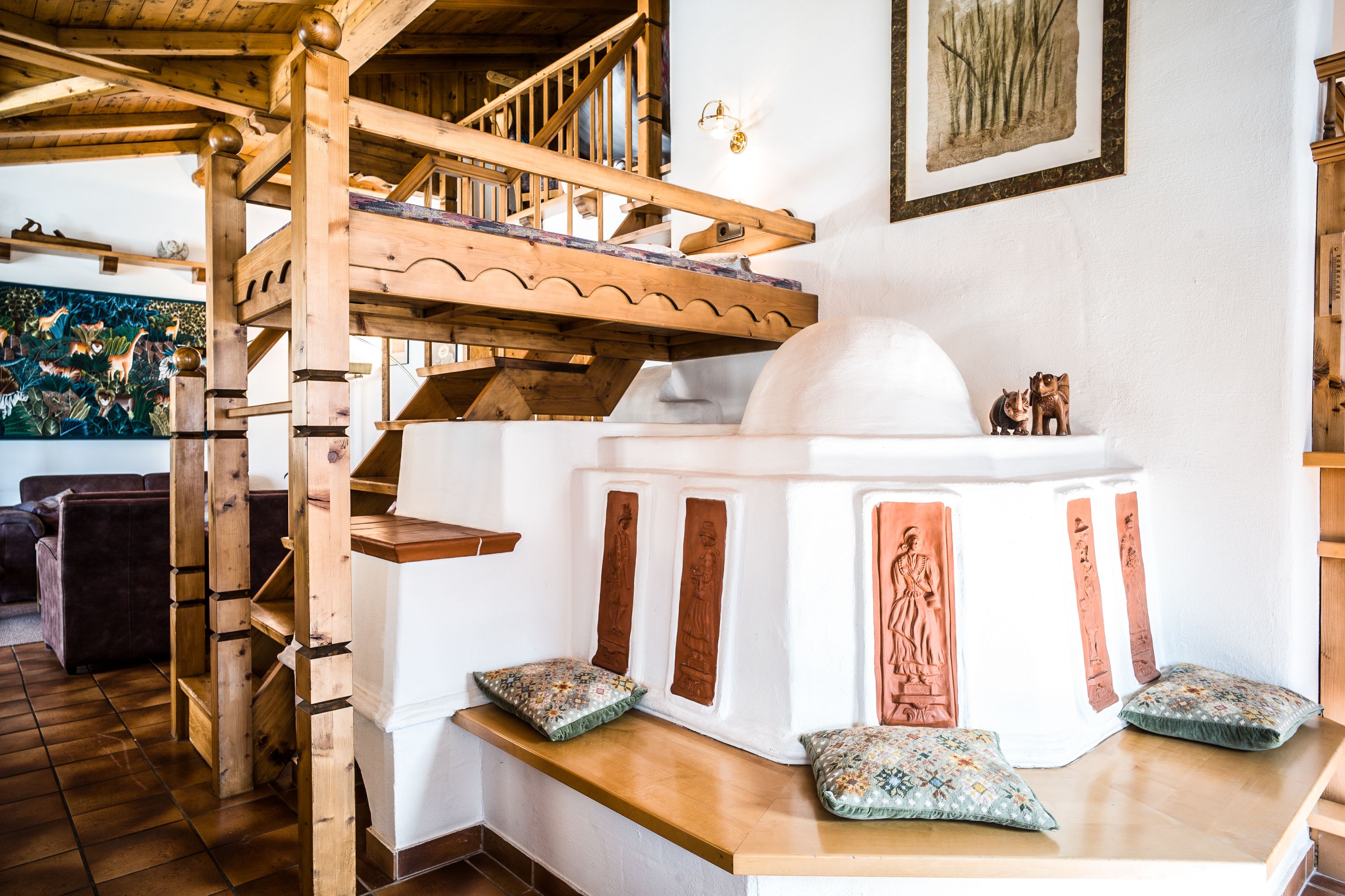 Una escalera de madera conduce a una zona superior con una estructura blanca y decorativa.