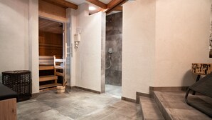 A modern bathroom with a shower, a wooden bench, and a small wooden table.