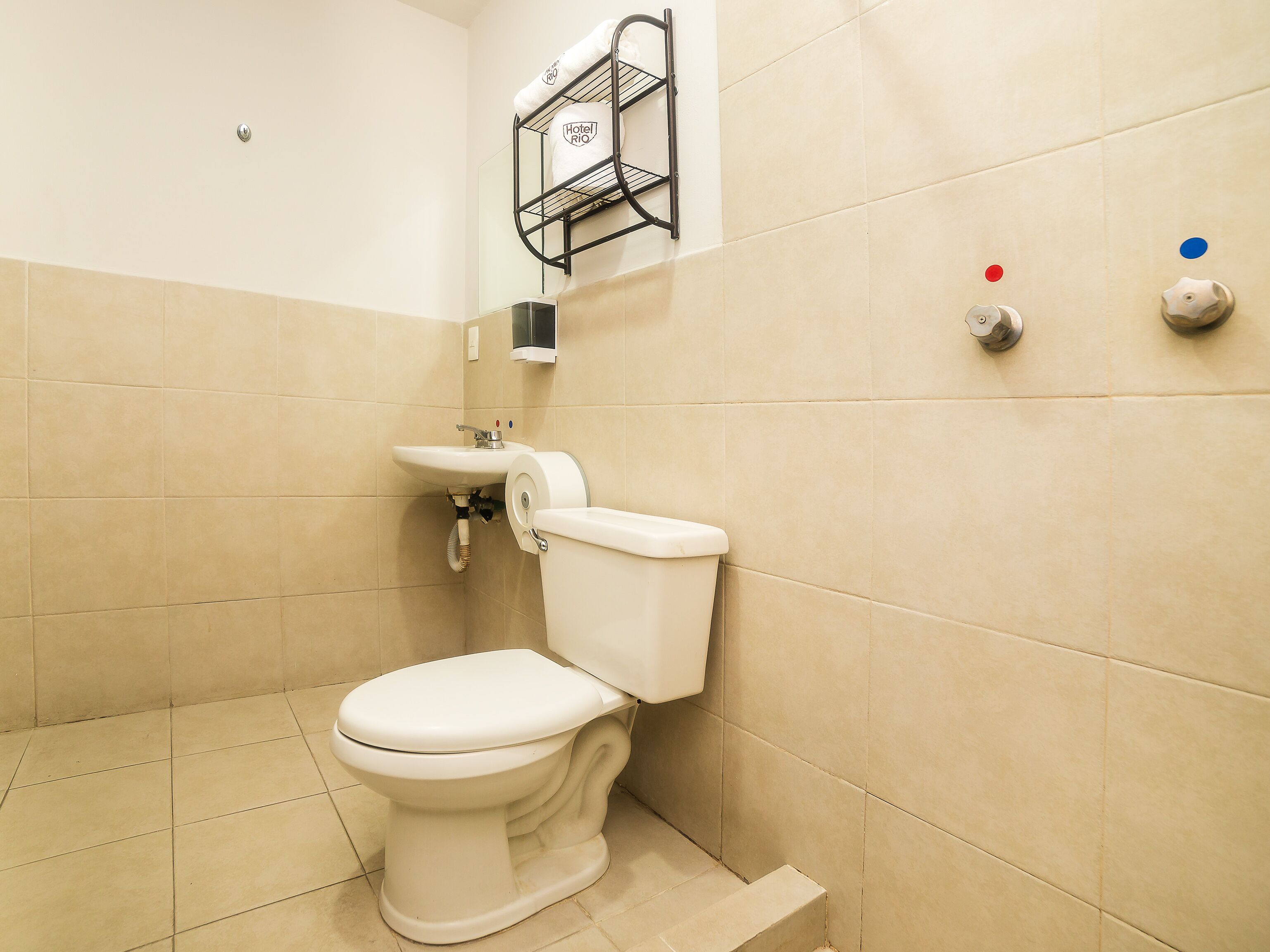 A bathroom with a white toilet, a sink, and a towel rack.