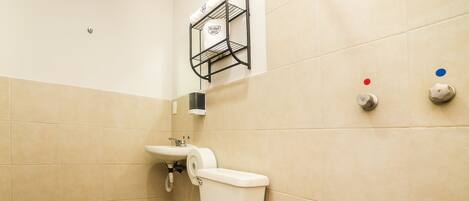 A bathroom with a white toilet, a sink, and a towel rack.