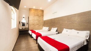 A hotel room with three beds, a TV, a bathroom, and a wooden accent wall. - Hotel Río Puebla Centro (Puebla)