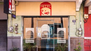 The exterior of Hotel Rio with a large entrance, potted plants, and visible electrical meters. - Hotel Río Puebla Centro (Puebla)