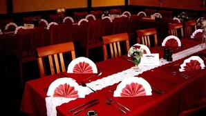 A restaurant with red tablecloths, white napkins, and wooden chairs. - Hotel zum Stern (Baumholder)