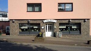 A building with a stone facade, two large windows, and a sign reading "Zum Stern M. Reich". - Hotel zum Stern (Baumholder)