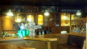 A bar area with wooden furniture, a counter, and shelves with bottles. - Hotel zum Stern (Baumholder)