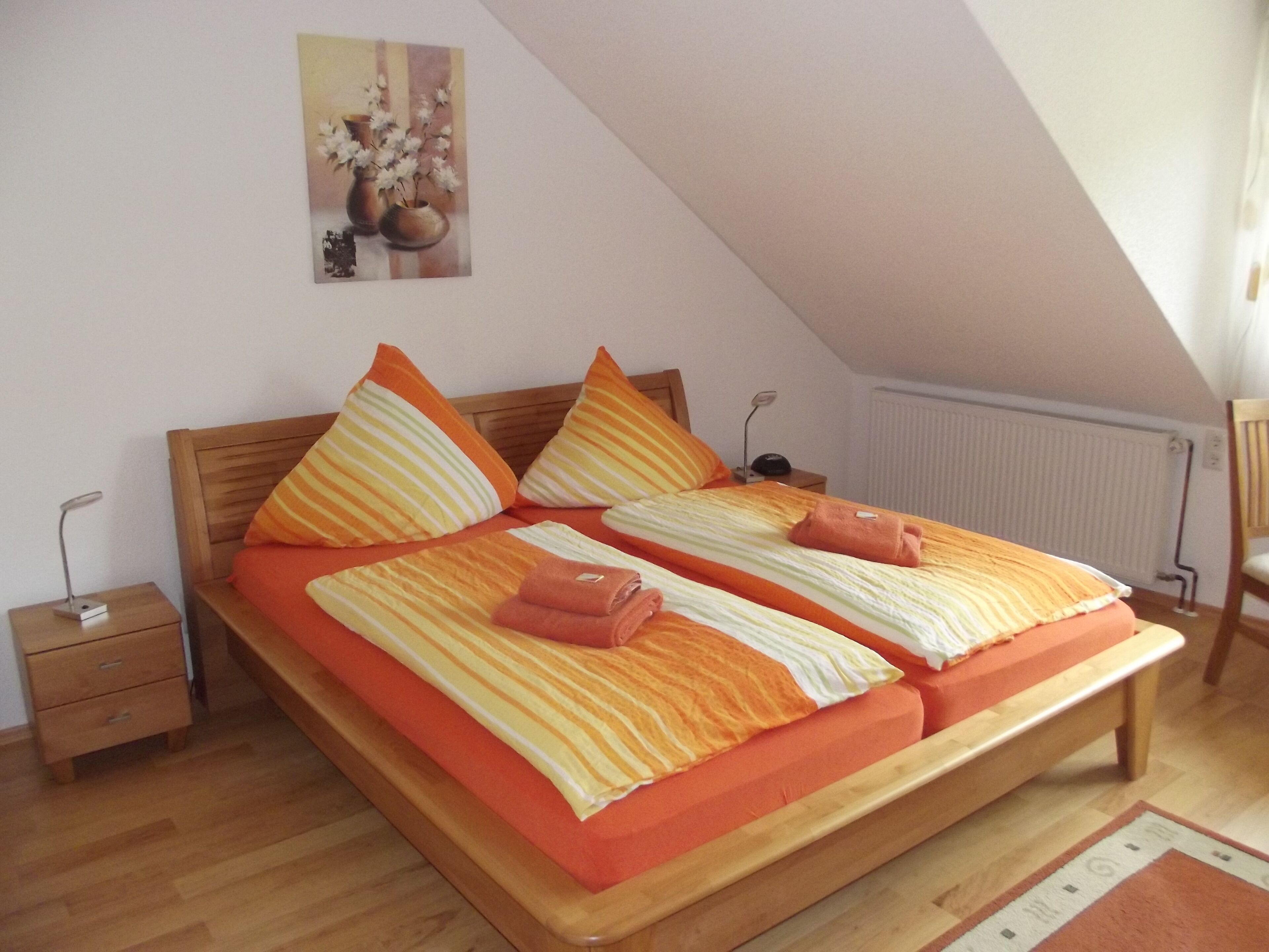 Ein Schlafzimmer mit einem Holzbett, gestreifter Bettwäsche und einem kleinen Nachttisch.