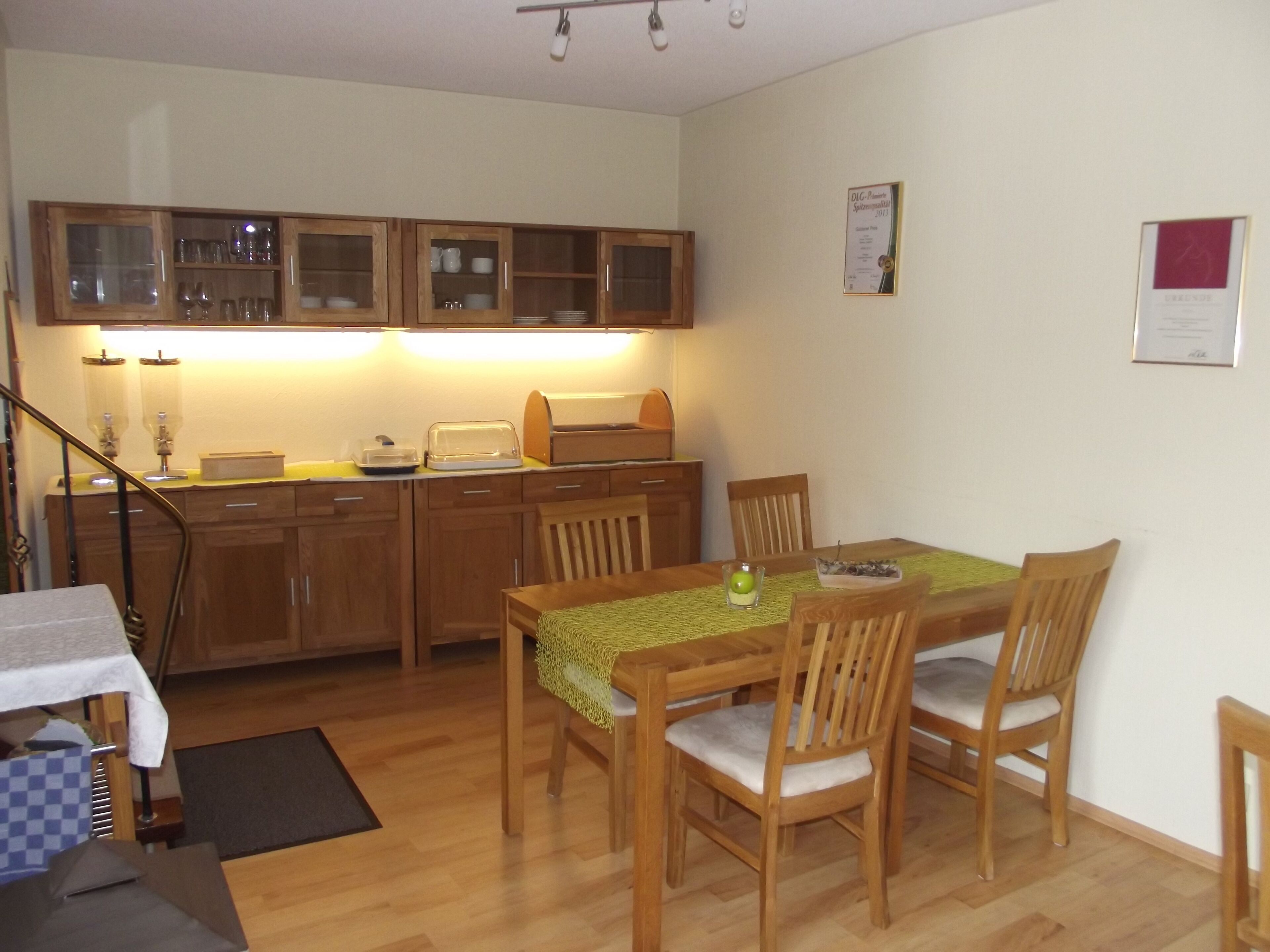 A compact kitchen with wooden cabinets, a dining table with chairs, and a small countertop with a toaster.