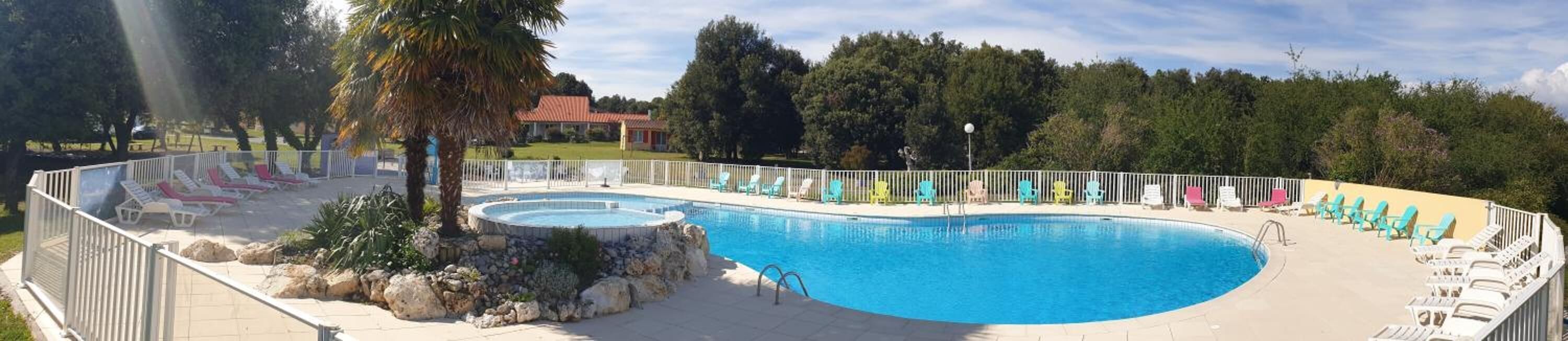 Una piscina grande y curvada con múltiples sillas de descanso y un pequeño espacio para hidromasaje.