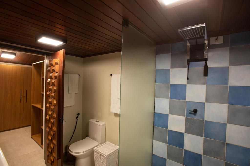 Ein Badezimmer mit Toilette, Dusche und einem Holzschrank.