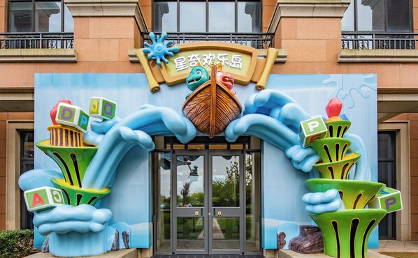 A building entrance with a colorful sign and playful decorations. - Hilton Dalian Golden Pebble Beach Resort (Dalian)