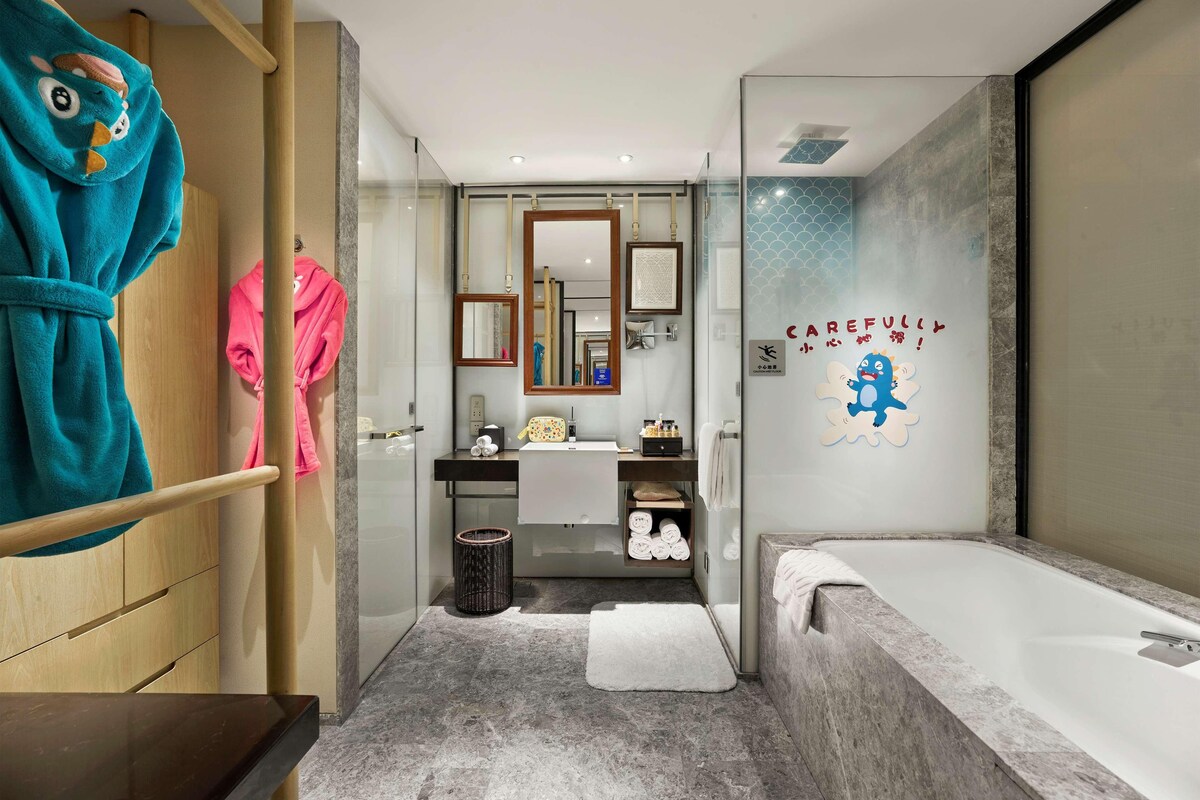 Een moderne badkamer met een groot bad, een douchecabine van glas en een wastafel met spiegel.