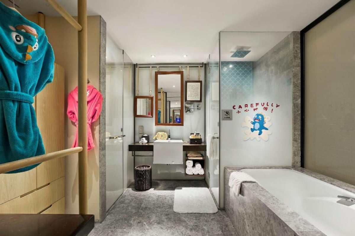 Un baño moderno con cabina de ducha de vidrio, tocador con espejo y bañera.