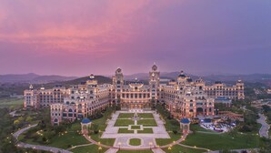Un grand hôtel somptueux, à la façade symétrique, doté de plusieurs tours et d’une cour intérieure.