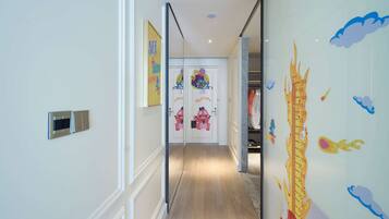 A hallway with a height chart on the wall, a welcome sign, and a children's room with cartoon characters.