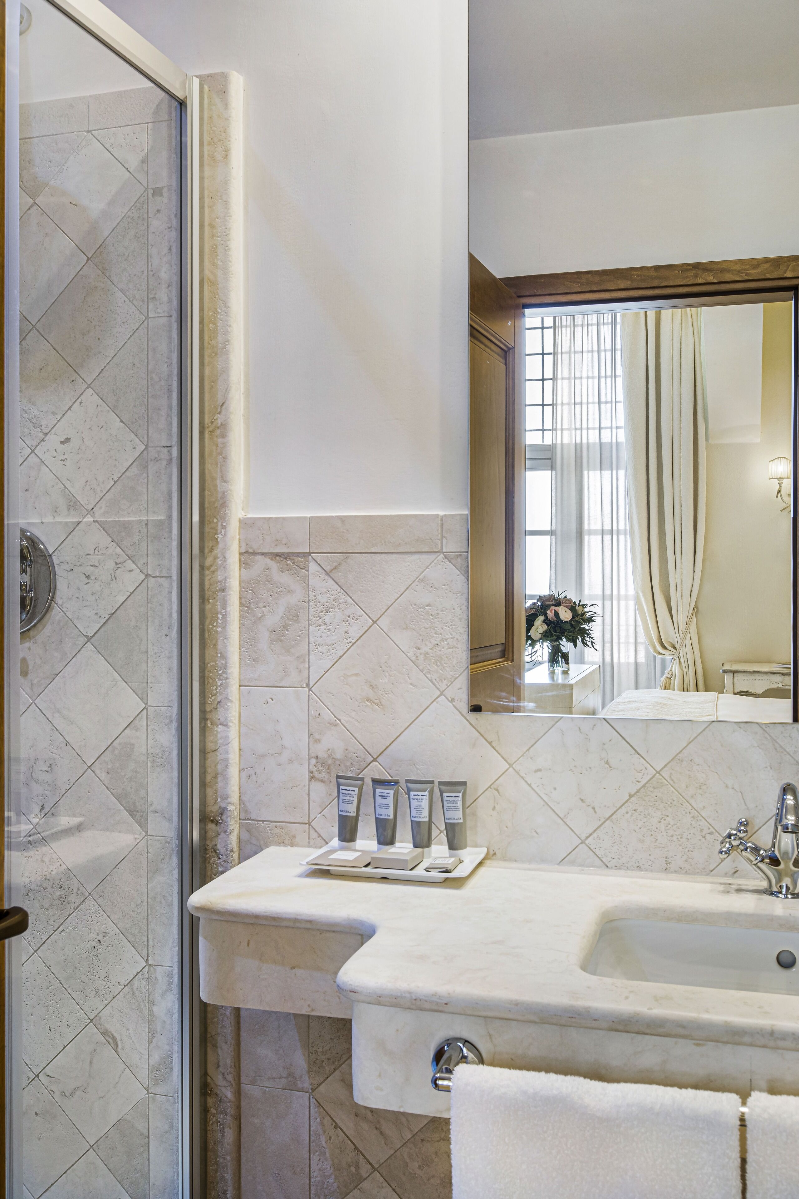 Une salle de bain avec une douche, un lavabo et un miroir.