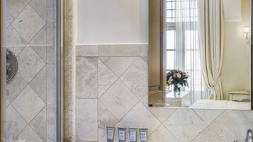 Ein Badezimmer mit Dusche, Waschbecken und Spiegel.